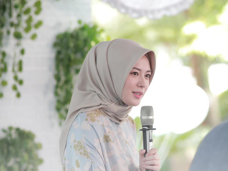 Seorang penceramah wanita bertudung bercakap menggunakan mikrofon